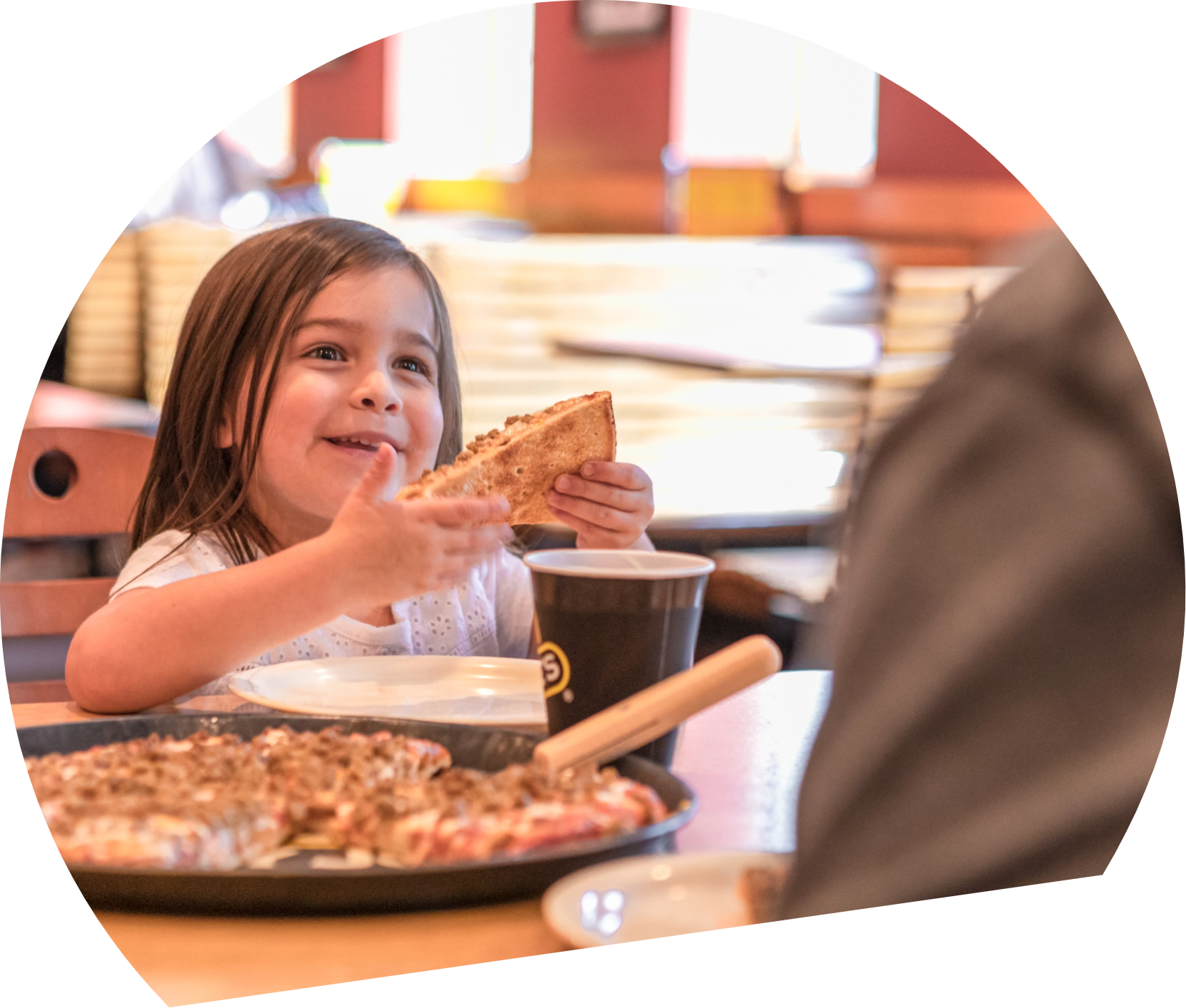 Round image with girl eating a slice of pizza
