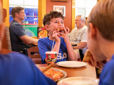 Boy enjoying a slice of Happy Joe's Pizza