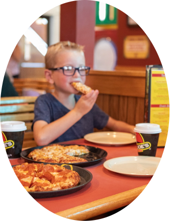 Young boy eating a slice of pizza