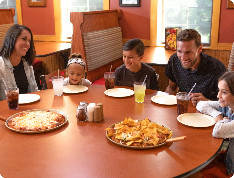 Family ready for pizza at Happy Joe's Pizza.