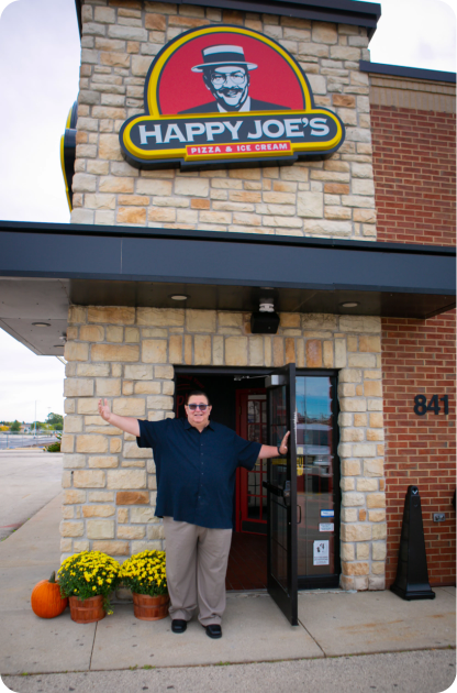 President & CEO Tom Sacco standing in front of a Happy Joe's.