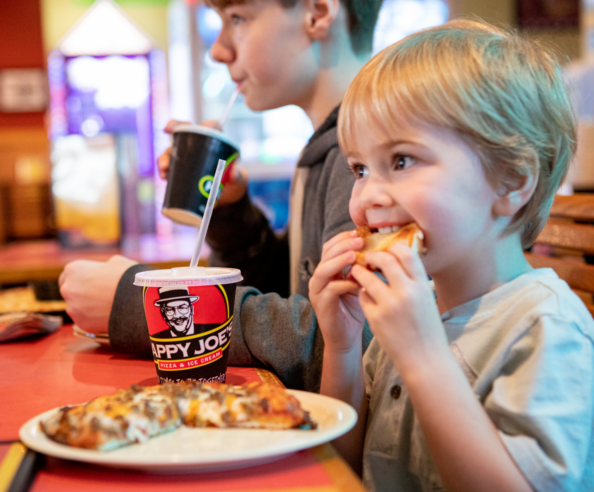 Young boy eating a slice of Happy Joe's Pizza