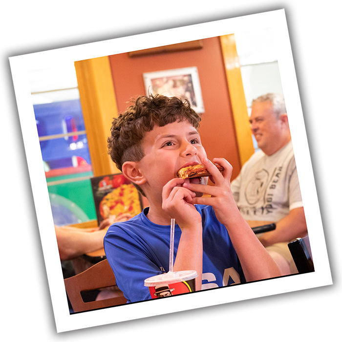 Photograph of Boy Eating Pizza