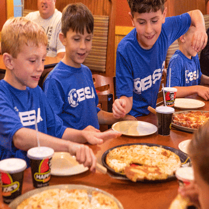 Ottumwa party packages soccer team eating pizza with drink cups