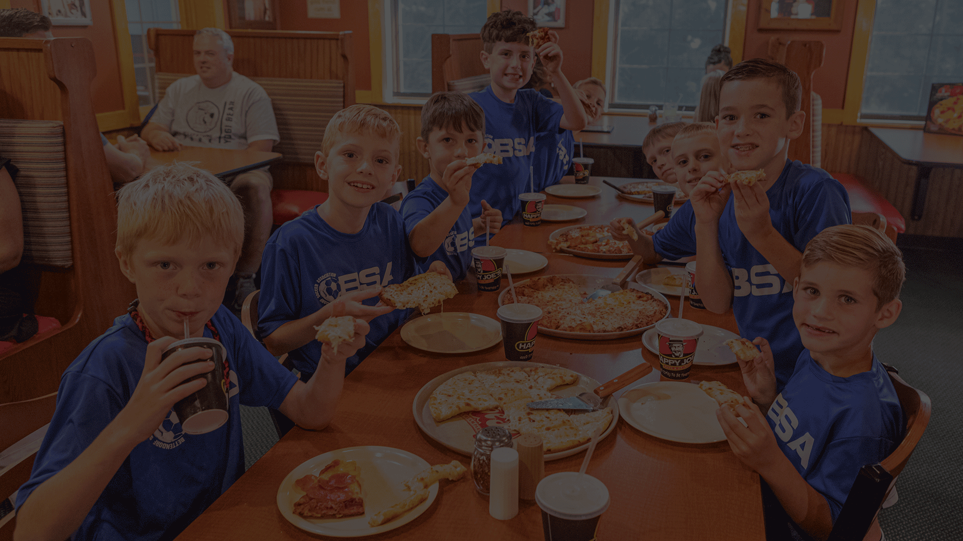 Faded foreground of boys soccer team pizza party